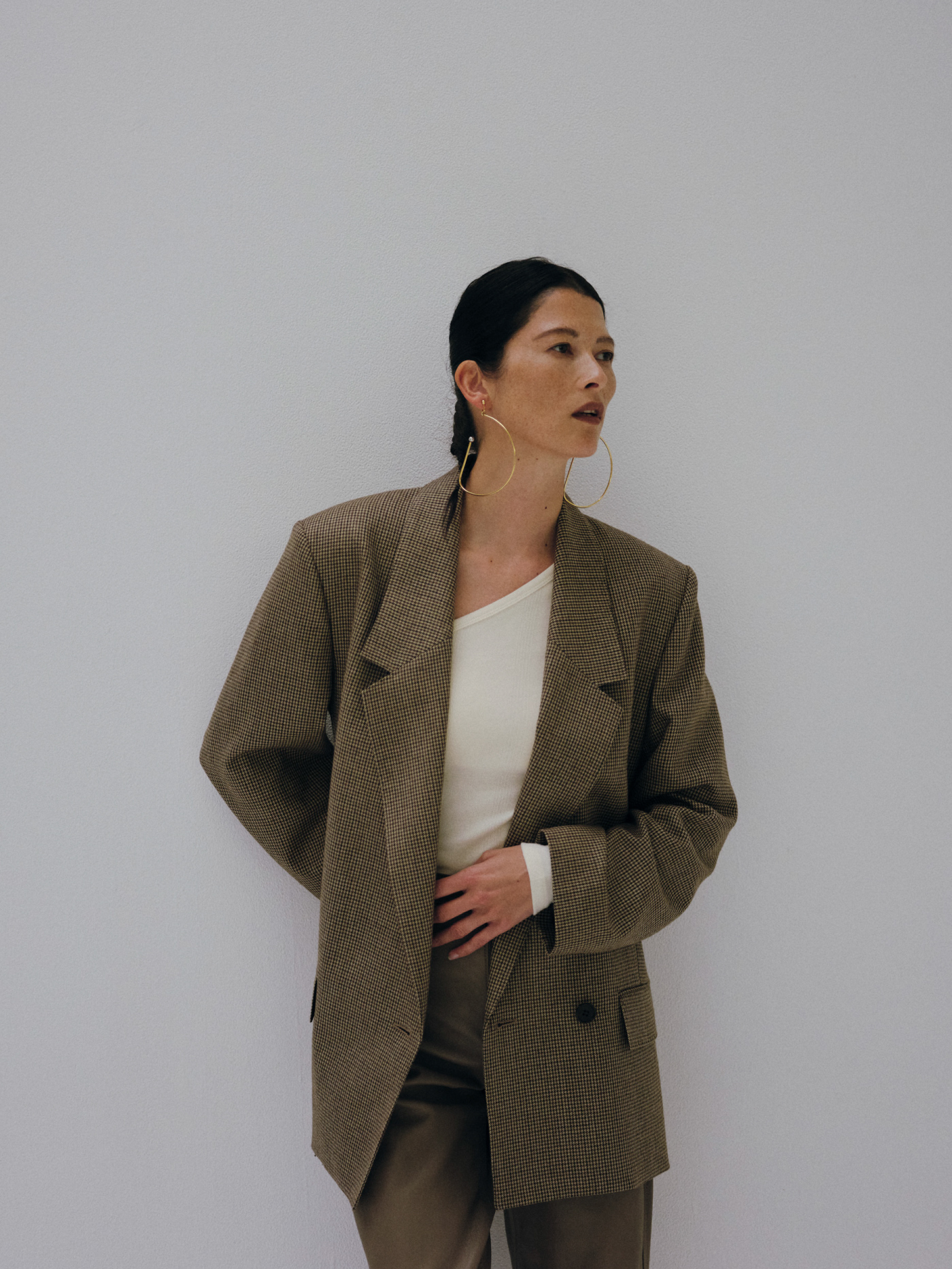 Double-breasted suit jacket & MILLER one-shoulder bodysuit & Box tuck suit pantsを着た女性
